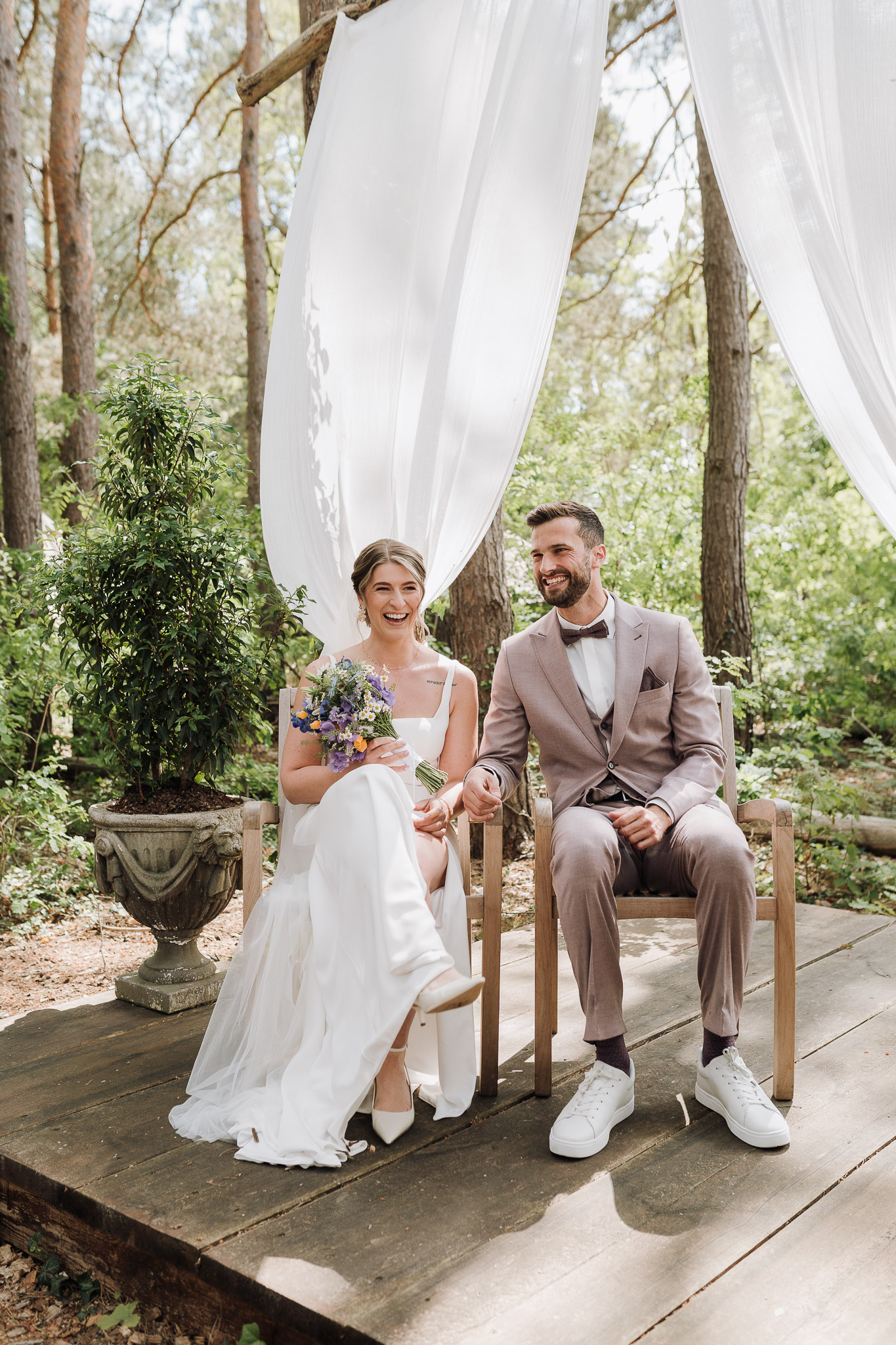 Hochzeit Framhouse Wandlitz, Freie Trauung, Hochzeitsfotografin Berlin, Emotionale ;Momente, Authentische Hochzeitsfotografie, Brautpaar sitzend, Braut lacht in die Kamera, Freie Trauung